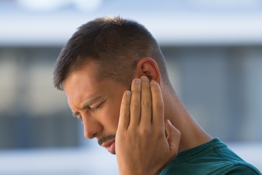 Young man with earache, otitis.